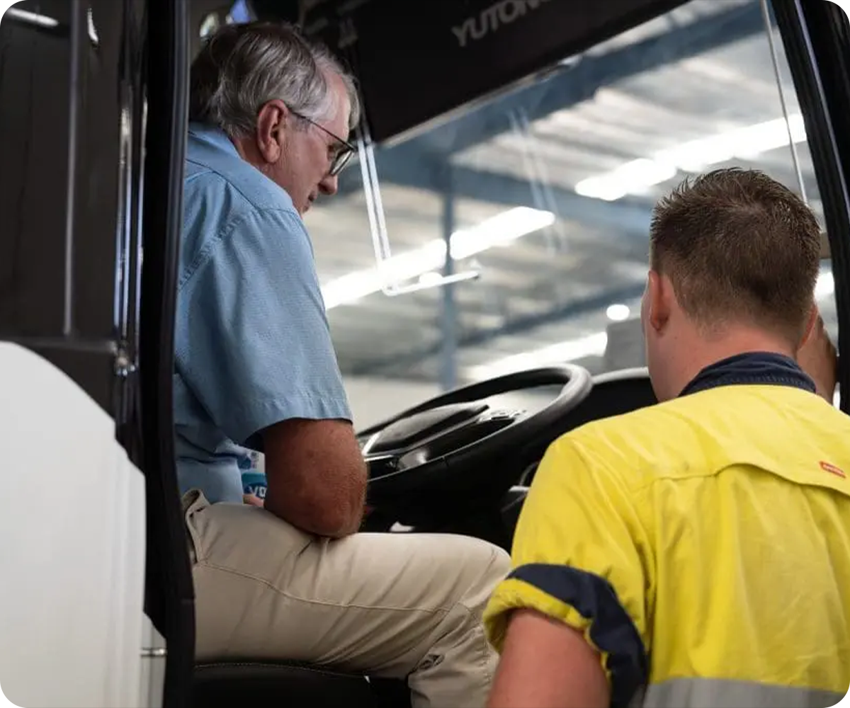 A VDI Australia employee helps a bus operator through the operation of their new bus